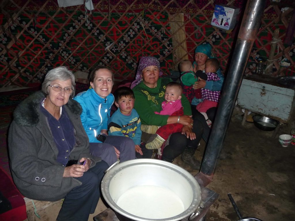 Four adults and four children inside a Kazakh yurt