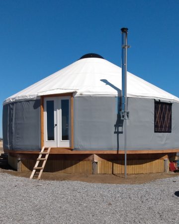 Grey yurt with a white roof