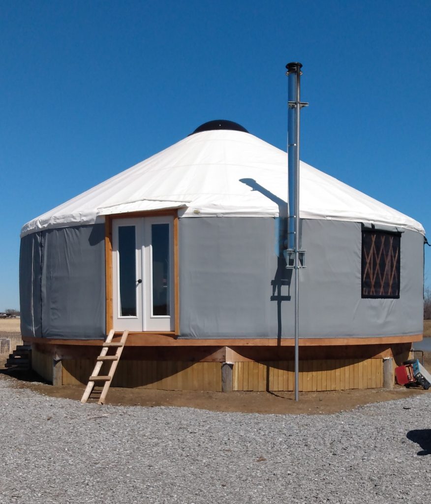 Grey yurt with a white roof 