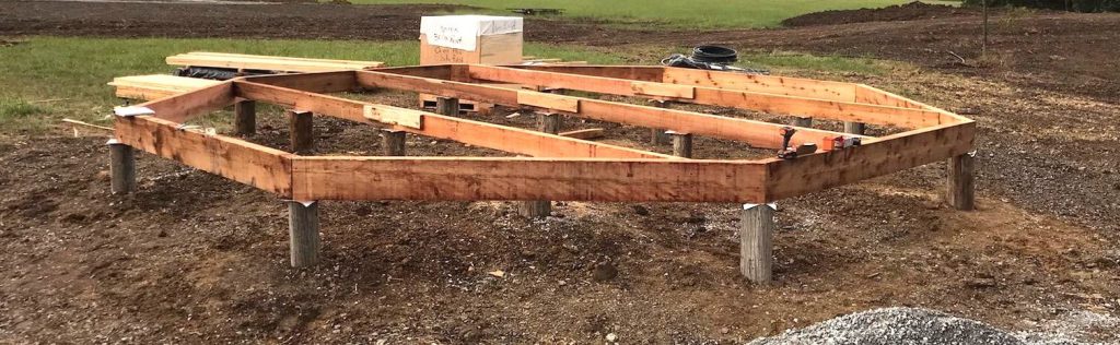 Cedar beams in an octagon shape on piers. 